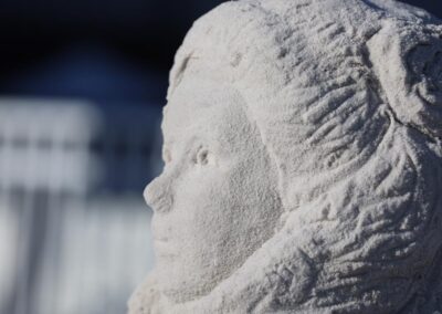 Close‑up of a detailed sand sculpture of a human head and upper torso.