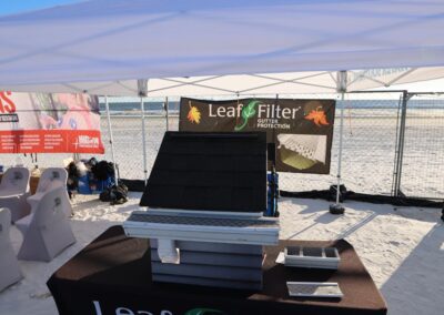 LeafFilter demo booth on the beach with a gutter display under a white canopy tent.